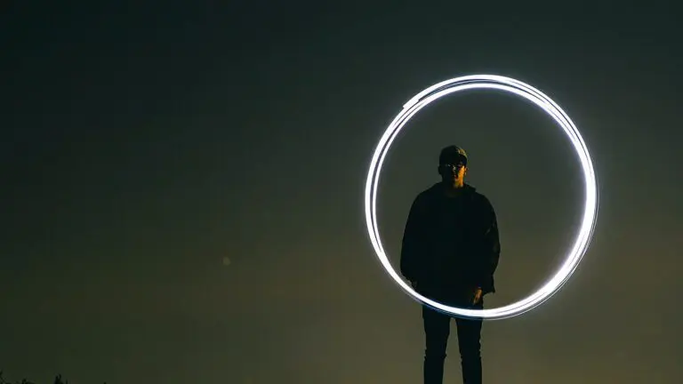 man standing at dusk with circle of light