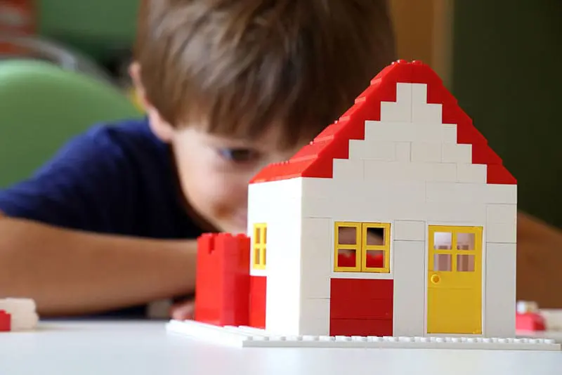 A-boy-looking-at-a-house-shaped-block