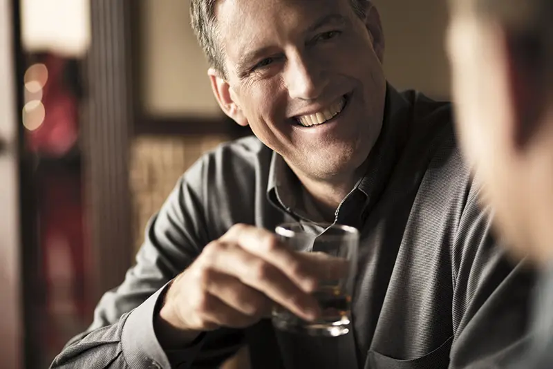 A-man-talking-while-drinking-whiskey