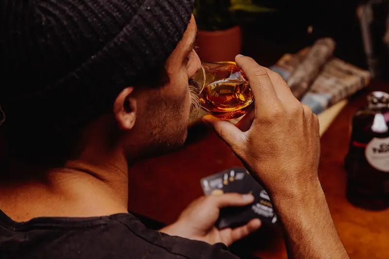 A-young-man-drinking-whiskey-during-a-board-game